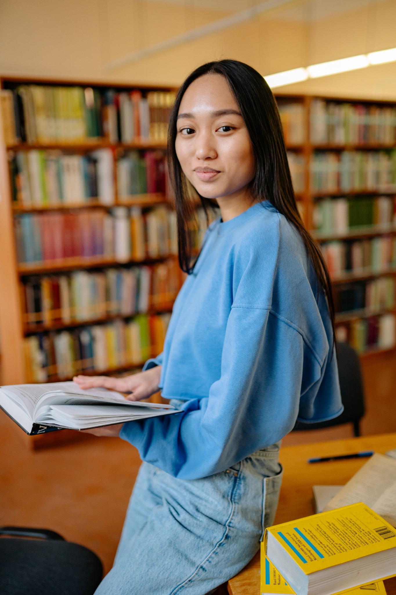 Estudiante en biblioteca con material académico